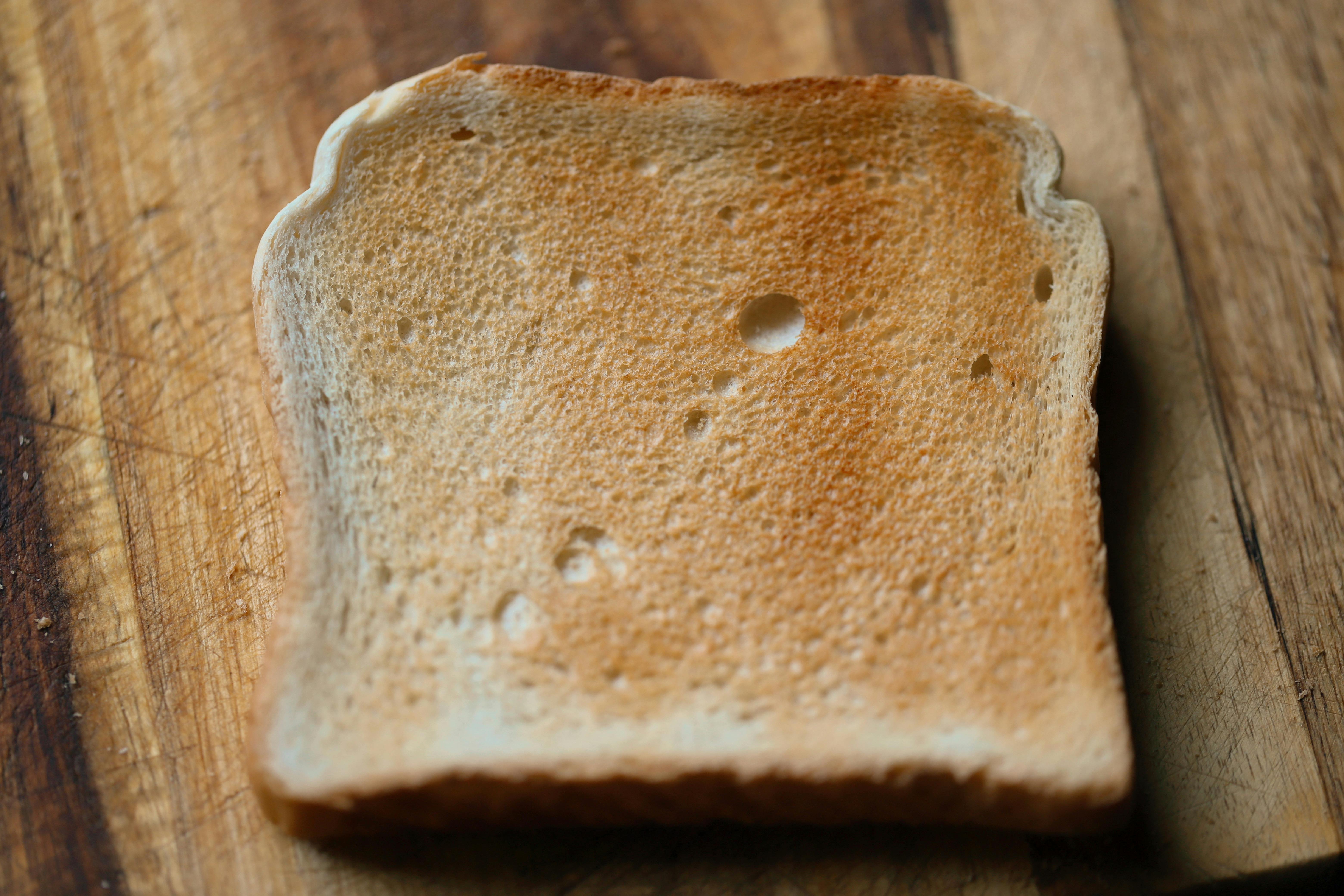 Image of a slice of toasted bread on wooden background.